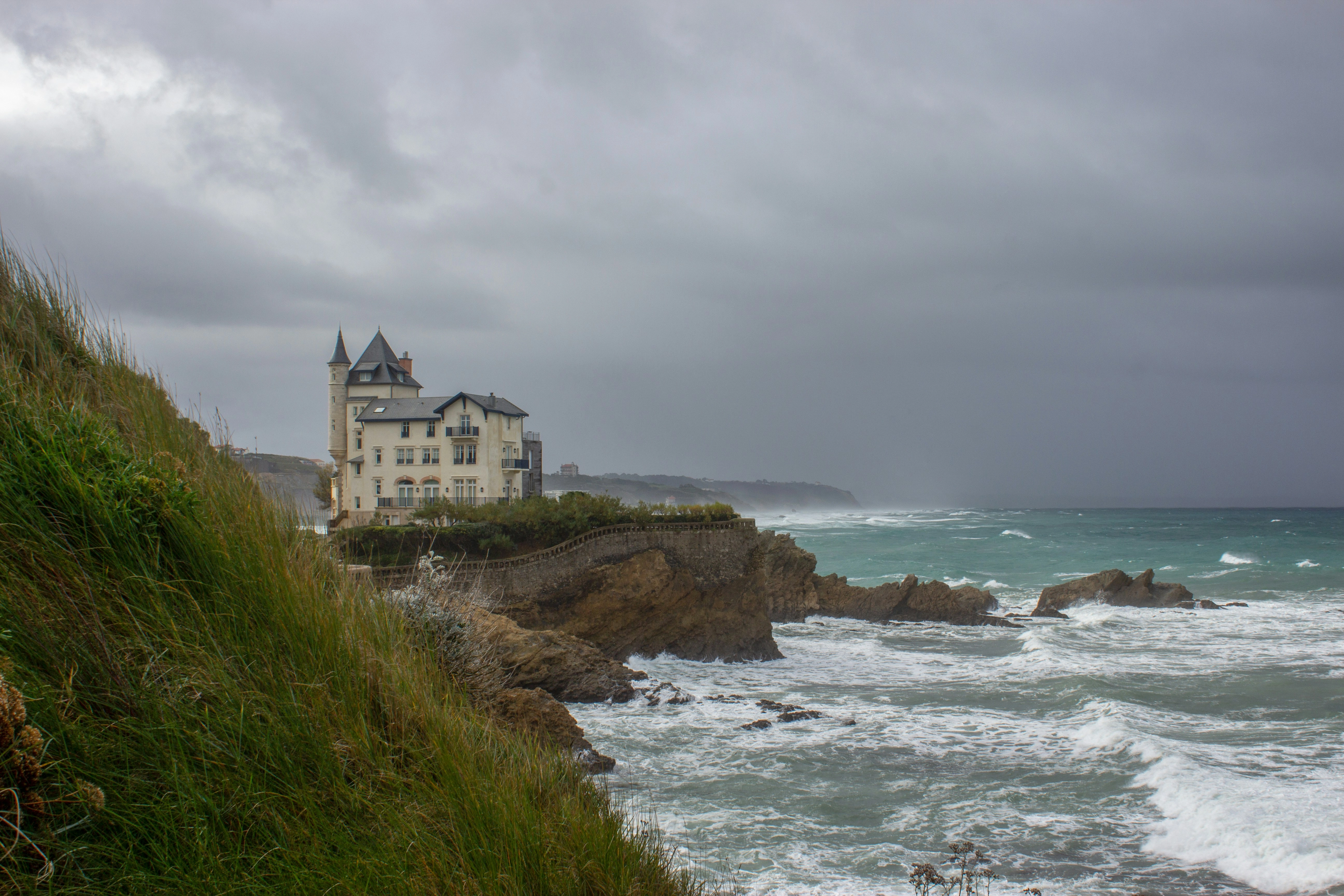 Vagues d'hiver contre les falaises de Biarritz sous un ciel orageux