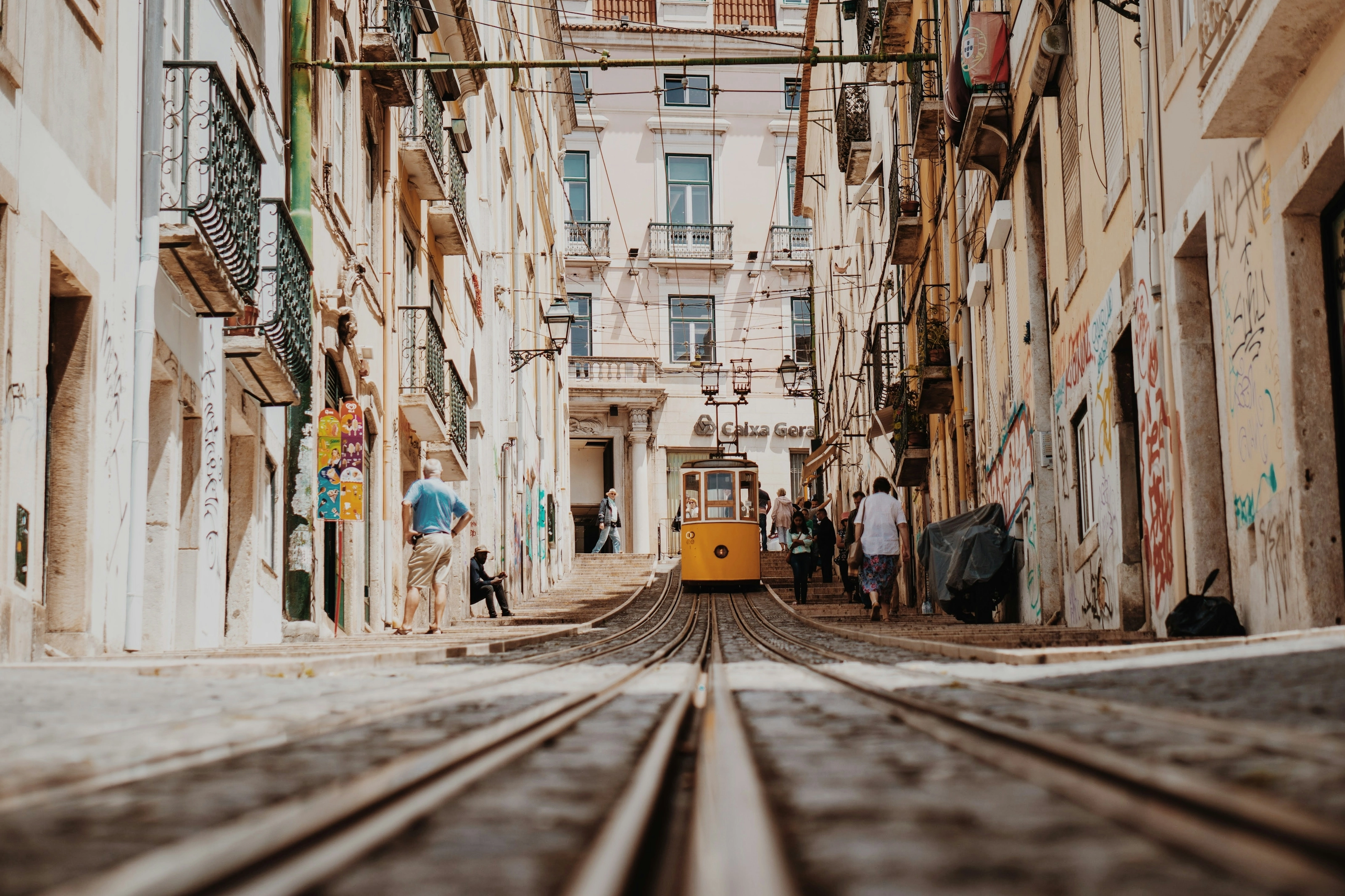 Tramway jaune traversant une ruelle étroite du quartier d'Alfama, Lisbonne