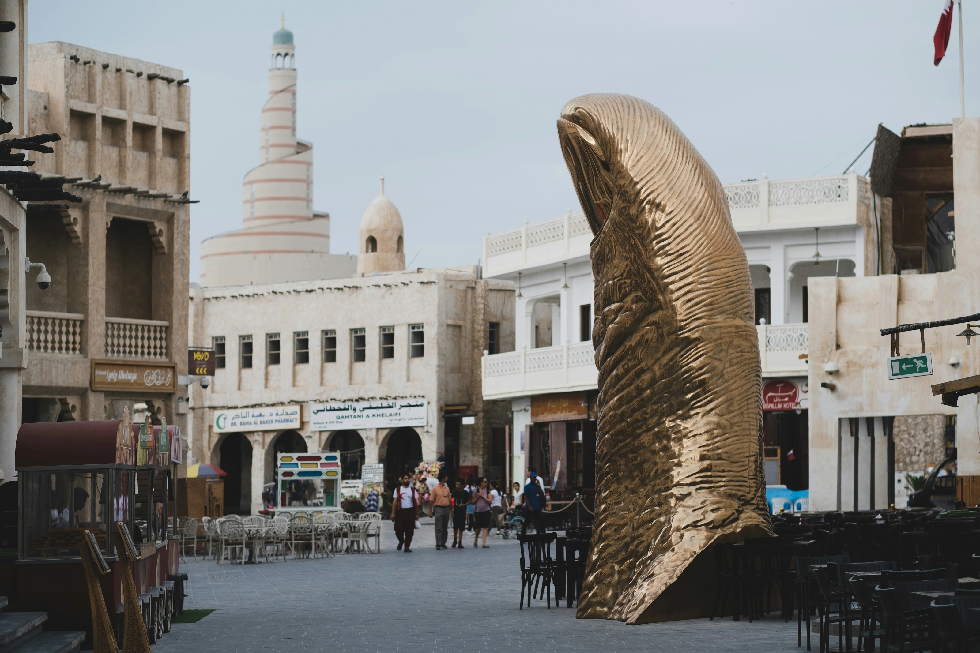 Place du Souk Waqif à Doha avec sa sculpture de faucon doré et la tour spiralée du centre Fanar