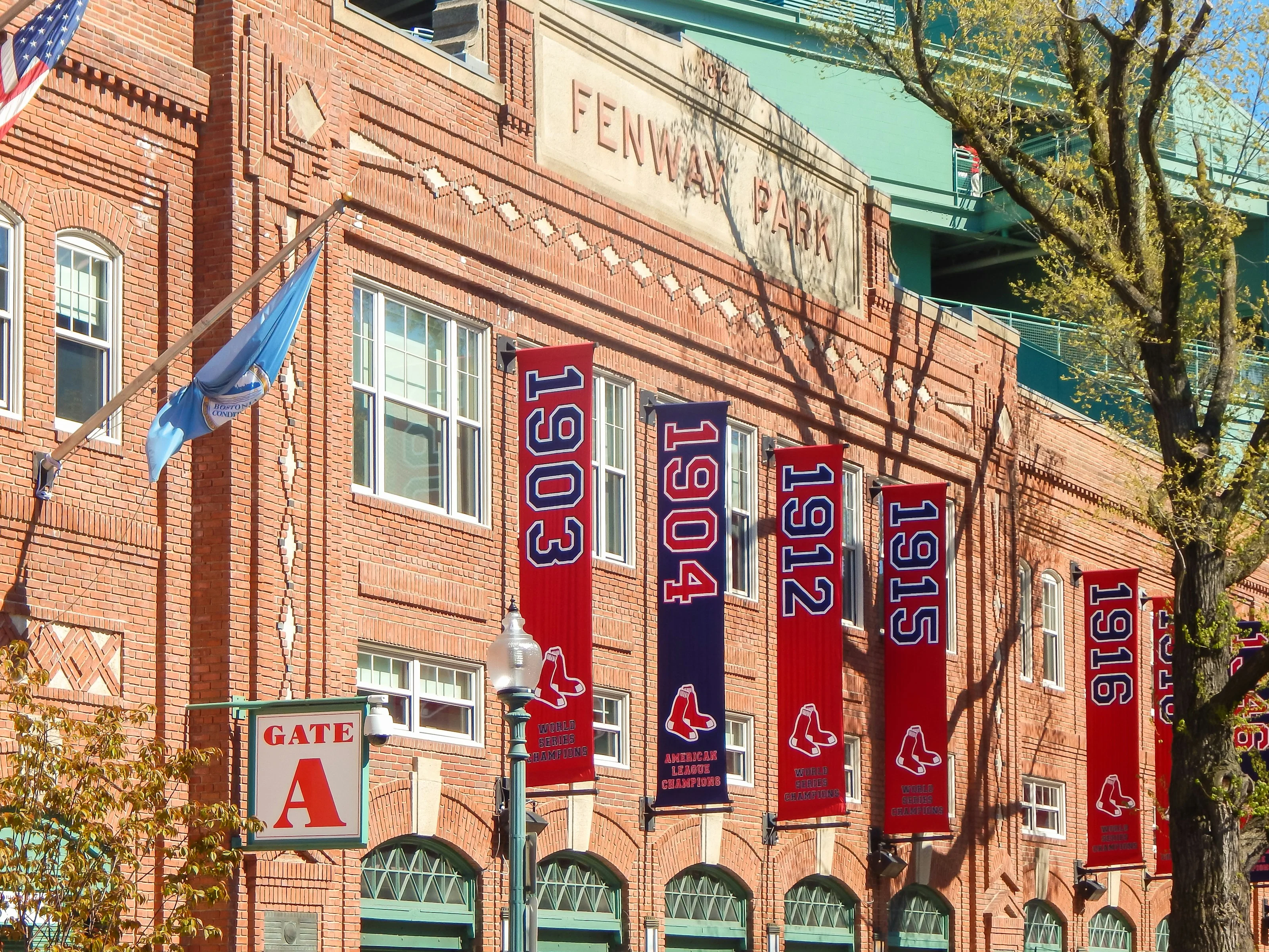 Fachada de entrada de Fenway Park decorada con banderolas de títulos de la World Series